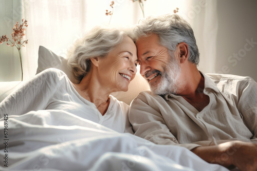 An elderly couple in love, a man and a woman in bed in the morning. Love and romance of two people. Tenderness and relaxation. Happy morning for lovers. Valentine's Day.