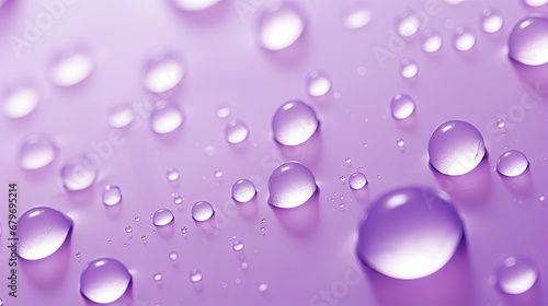  a close up of water droplets on a purple and pink background with a light reflection of the water on the left side of the image.