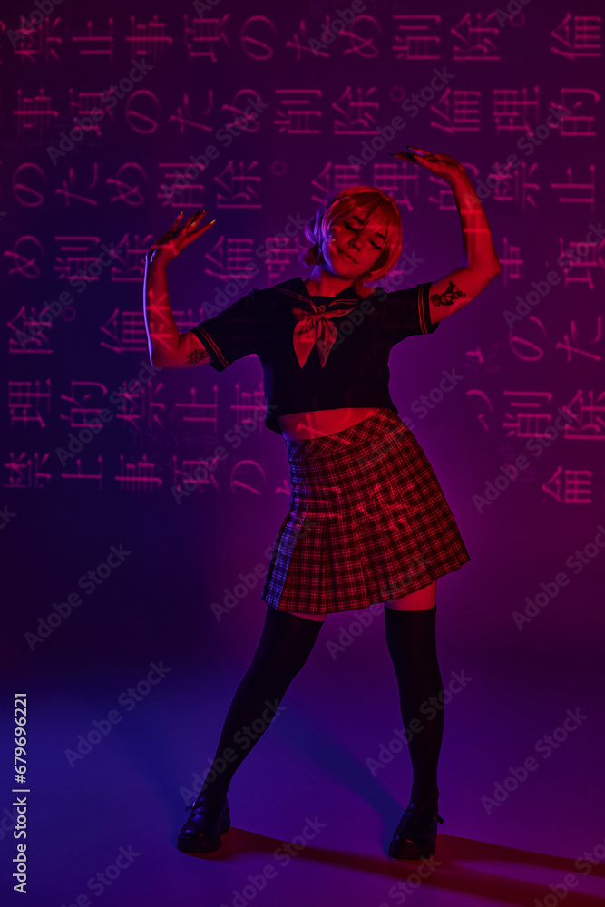 tattooed anime woman in school uniform posing on neon purple backdrop with hieroglyphs projection tattooed anime woman in school uniform posing on neon purple backdrop with hieroglyphs projection