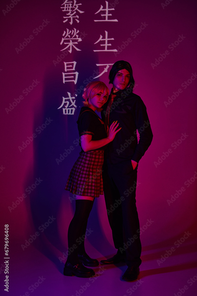 couple of students in uniform in neon light on purple backdrop with hieroglyphs, trendy cosplayers couple of students in uniform in neon light on purple backdrop with hieroglyphs, trendy cosplayers