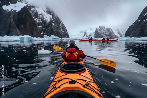 a person in a kayak on a body of water with ice and snow © Ion