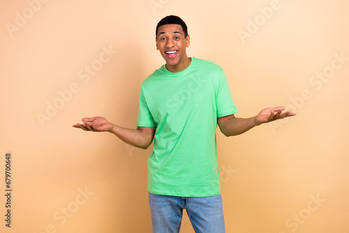 Photo portrait of attractive young man raise hands talking conversation wear trendy green clothes isolated on beige color background