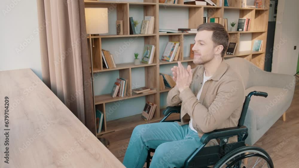 Young mature man alone in wheelchair indoor at home looking window thinking pondering pensive contemplate smiling posing at home near the bookcase Young mature man alone in wheelchair indoor at home looking window thinking pondering pensive contemplate smiling posing at home near the bookcase