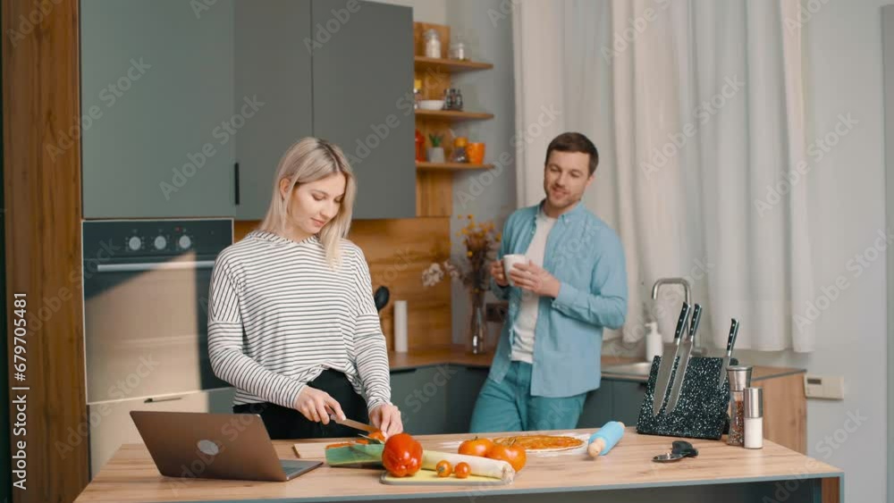 Young happy active family couple communicating together preparing food at home, carefree joyful husband and wife having fun cooking healthy romantic dinner meal listen to music in modern kitchen Young happy active family couple communicating together preparing food at home, carefree joyful husband and wife having fun cooking healthy romantic dinner meal listen to music in modern kitchen