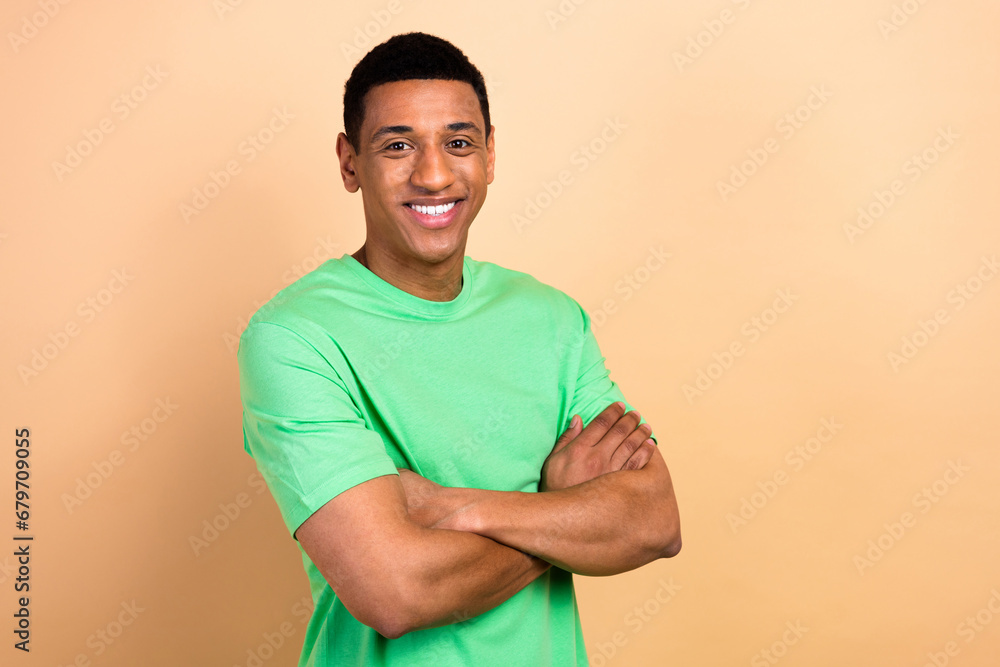 Photo portrait of nice young male posing crossed hands shopping wear trendy green outfit isolated on beige color background Photo portrait of nice young male posing crossed hands shopping wear trendy green outfit isolated on beige color background