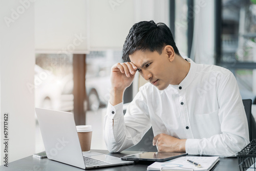 Stress businessman is sitting at table, under stress from working.