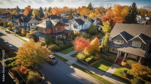 Drone aerial view of detached house neighbourhood community street with autumn fall colours nature trees surrounding. Real estate, development and suburban cityscape background.