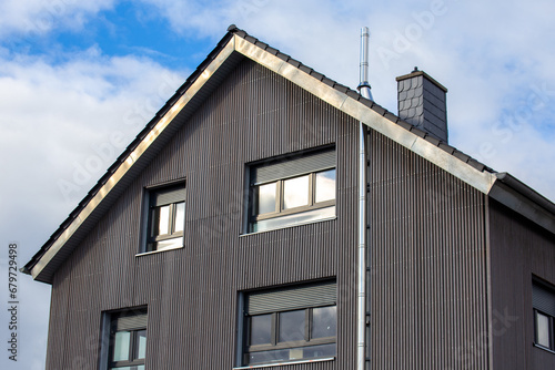 Moderne Fassade mit Holzpaneelen an einem neuen Wohnhaus photo