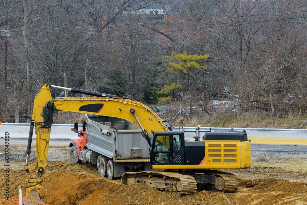 excavator loading earth onto a dump truck