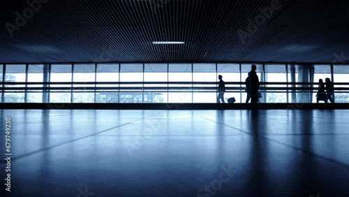 Traveler silhouettes with moving walkway at airport hall 
