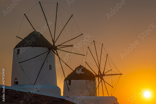 Sunset behind the iconic Mykonos windmills Mykonos island, Cyclades Islands, Aegean Sea, Greece,