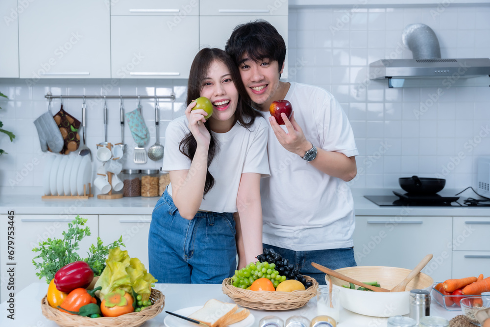 Happy Family portrait of loving young asian of having fun standing a cheerful preparing food and enjoy cook cooking with vegetables, meat, bread while standing on a kitchen Condo life or home