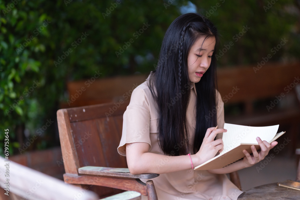 Obraz premium Happy of Young asian teen girl college student Taking written Notes to on notebook.Online education, elearning concept,freelance people businessfemale