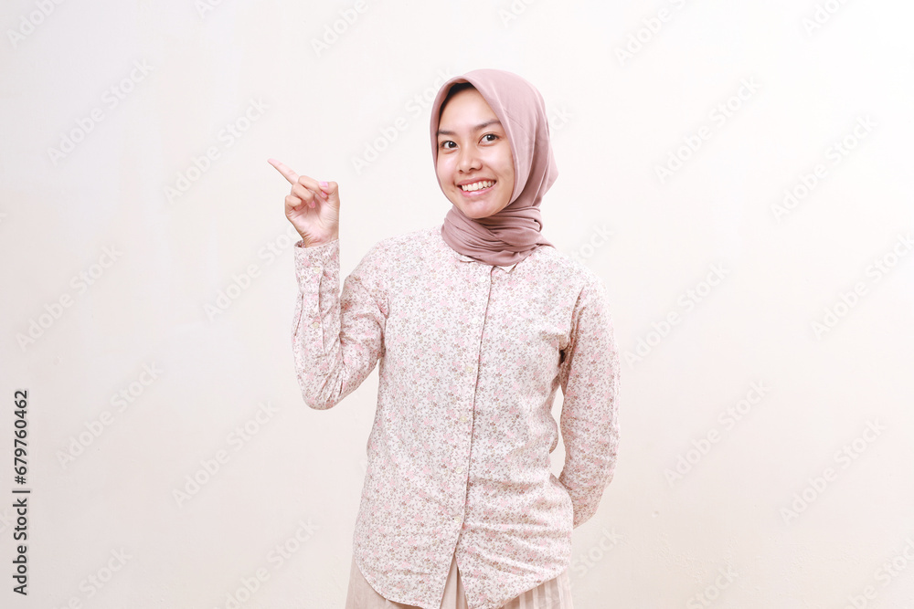 Happy young asian muslim girl standing while presenting beside her on empty space. Isolated on white Happy young asian muslim girl standing while presenting beside her on empty space. Isolated on white