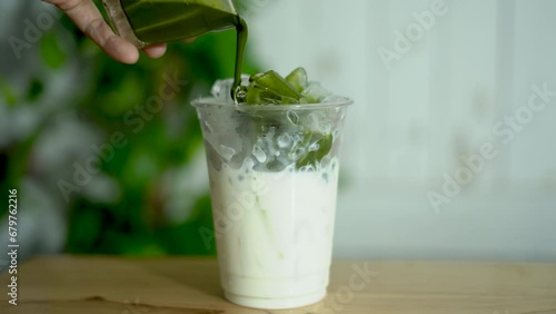 Pour the liquid of Matcha into a milk ice plastic cup to make an iced Matcha green tea latte.
