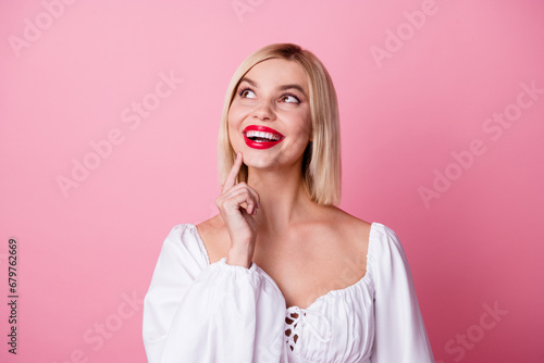 Photo of cute adorable minded girl dressed white stylish clothes hand touch chin look empty space isolated on pink color background