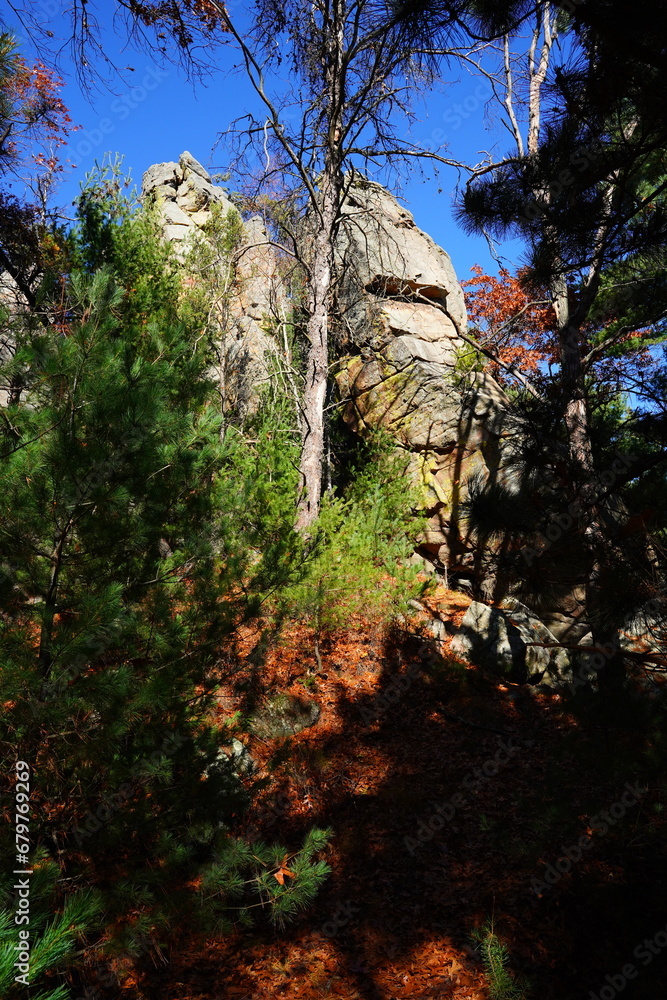 Tall rock stone formations sit in a forest for rock climbing.