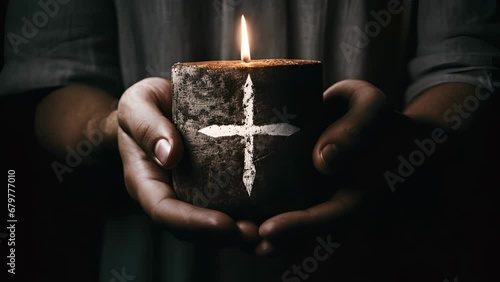 Concept photo of a persons hand holding a crossshaped candle, with the ashes on their forehead forming a crosslike pattern. The contrast between the white candle and the dark ashes creates photo