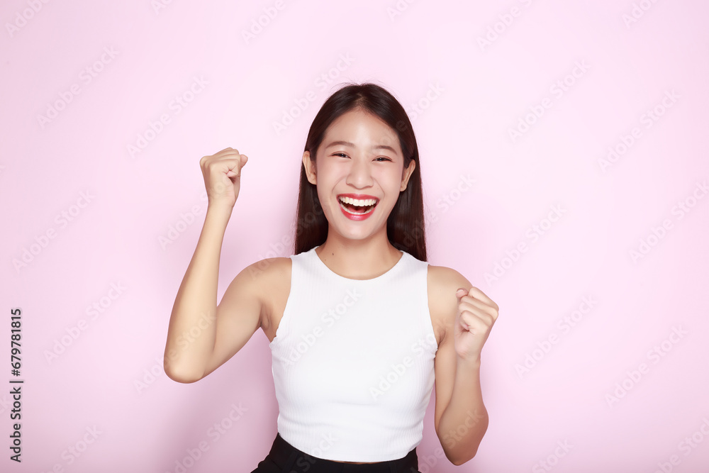 Portrait of a beautiful young woman in a light pink background, The Asian woman was acting very cheerful, Beautiful girl smiling happily. Portrait of a beautiful young woman in a light pink background, The Asian woman was acting very cheerful, Beautiful girl smiling happily.