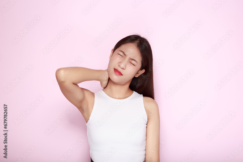 Portrait of a young woman in a light pink background, Asian woman experiencing pain in her body. - obrazy, fototapety, plakaty 