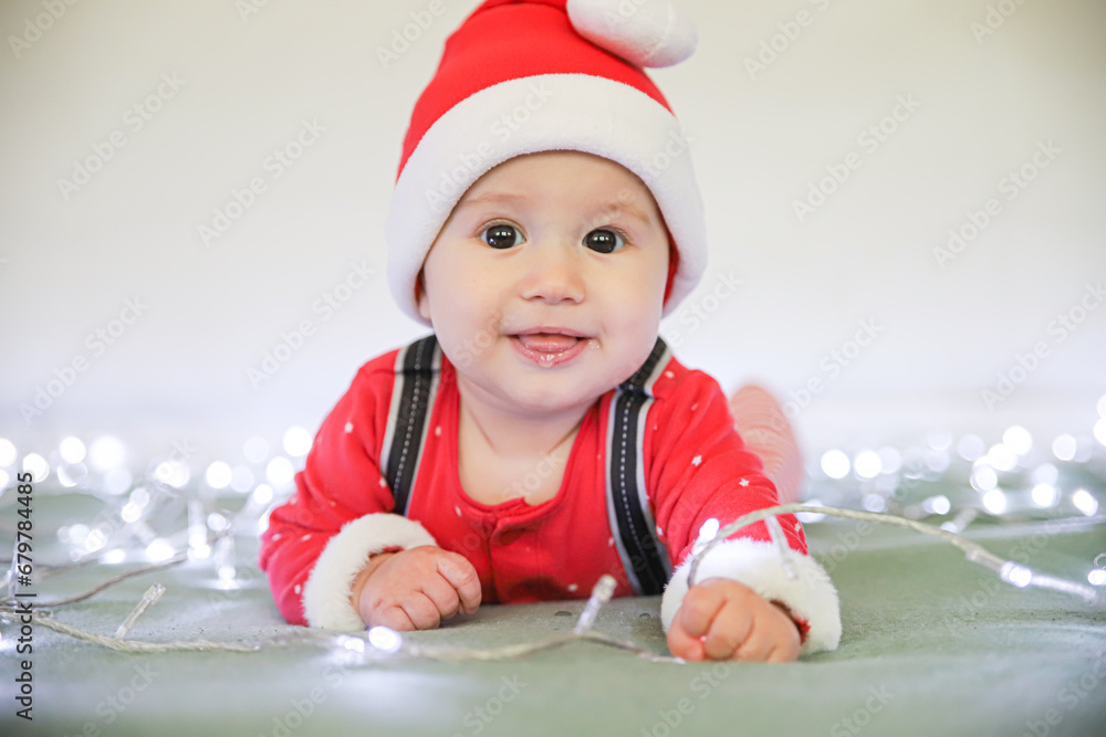 Portrait of a little child in a red Santa Claus hat for New Year and Christmas. Big eyes drooling. Postcard with space for text Portrait of a little child in a red Santa Claus hat for New Year and Christmas. Big eyes drooling. Postcard with space for text