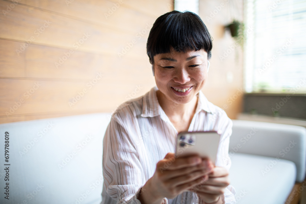 Cheerful Asian Woman Enjoying a Video Call on Mobile Phone Cheerful Asian Woman Enjoying a Video Call on Mobile Phone