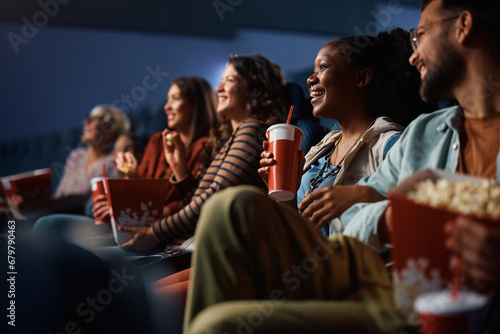 Happy black woman enjoying in movie projection in cinema. photo