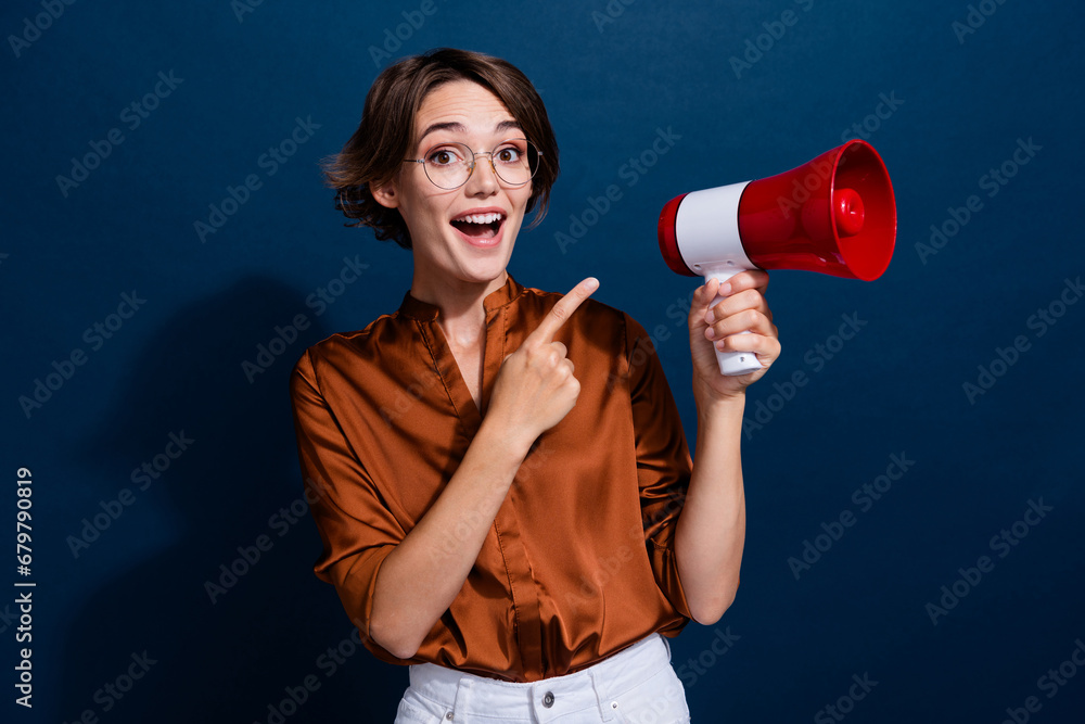 Photo portrait of lovely young lady point excited loudspeaker dressed stylish brown blouse isolated on dark blouse color background Photo portrait of lovely young lady point excited loudspeaker dressed stylish brown blouse isolated on dark blouse color background