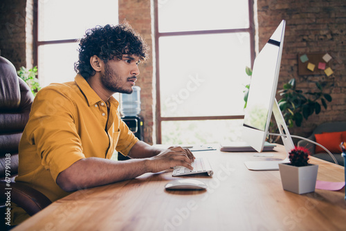 Photo portrait of handsome young guy wear yellow shirt busy focused boss check report look monitor stylish room interior home office design