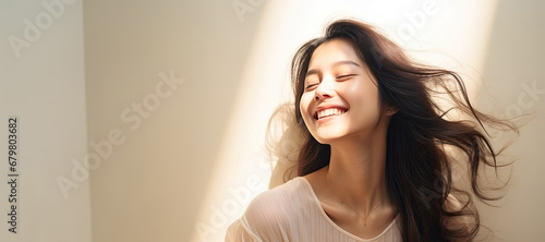 Portrait of beautiful smiling asian woman with long hair and closed eyes photo