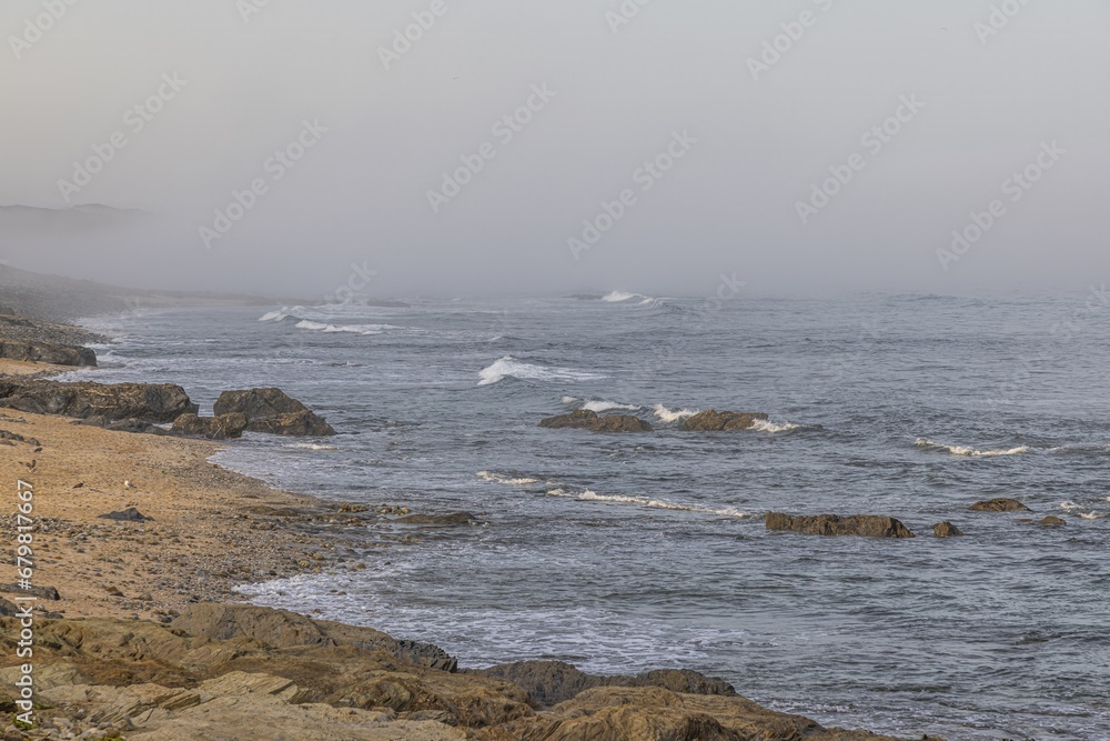 Fototapeta premium View of the turbulent and foggy Atlantic Ocean at Praia Aivados in Portugal in the morning light