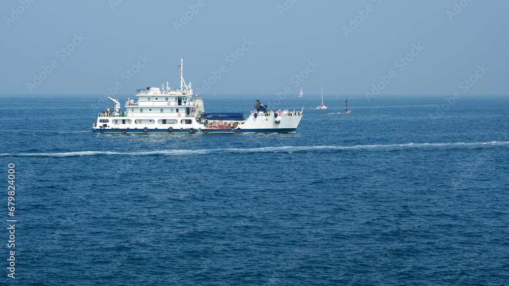 Panoramic view of a white ship (working barge) in the Adriatic Sea. Several sailing yachts in the background. Copy space.