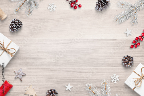 Top view flat lay Christmas composition on wooden table with festive decorations, featuring copy space in the center