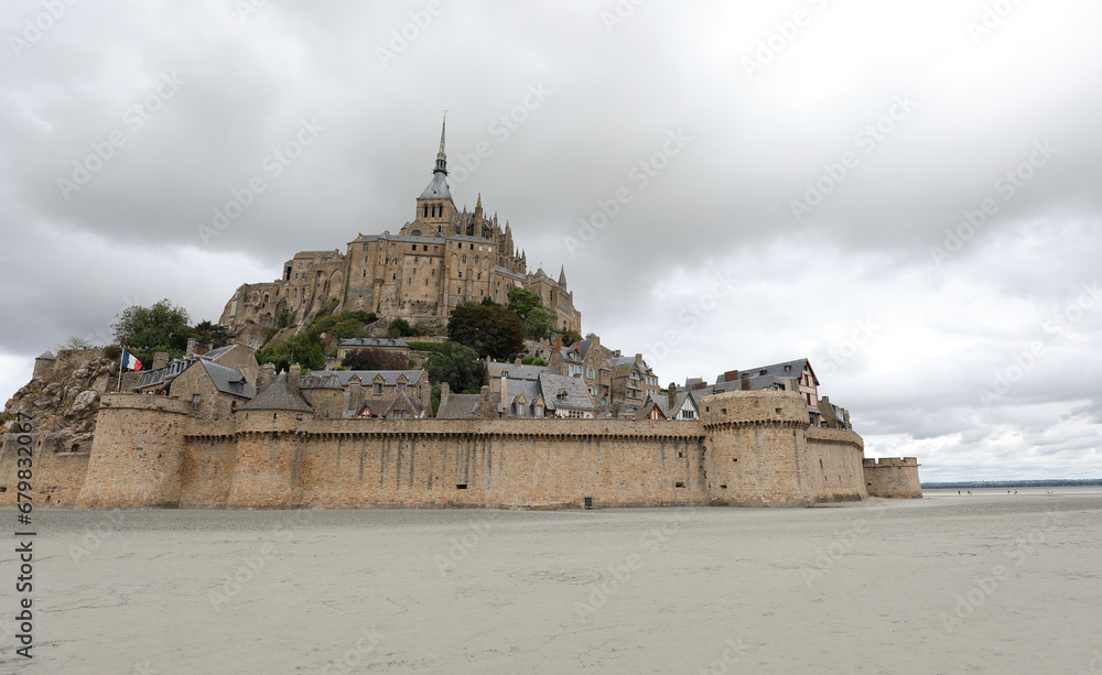 famous ancient Mont Saint Michel abbey above the hill at low tide and the city wall