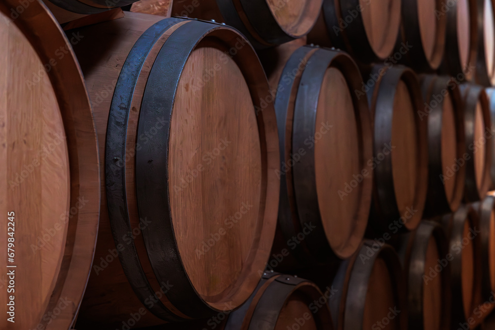 oak barrels filled with the best wine are arranged in the winery