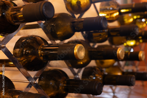 wine bottles filled with the best wine arranged in the cellar with a view of the black and gold stoppers