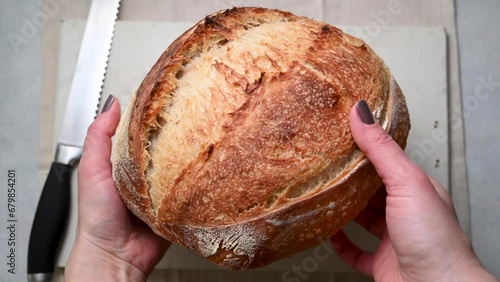 Traditional sourdough bread in female's hands, top view