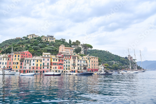 Panoramic view to the pier and colorful apartments and Italian architecture of the see and the boat Portofino, Italy