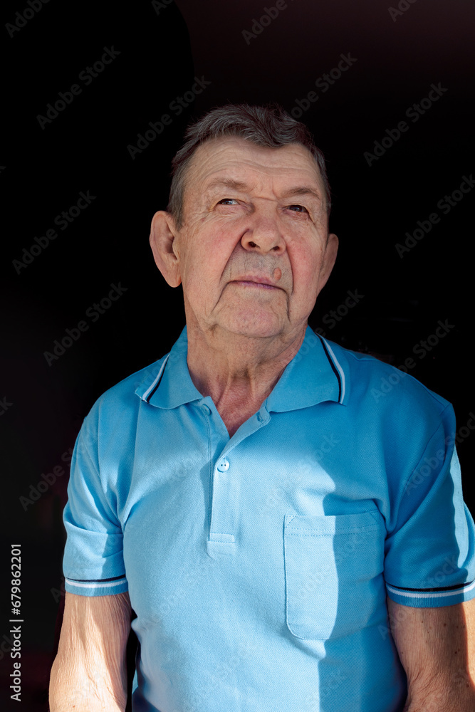 Portrait of sad elderly man on black background. Thoughtful look of old senior sitting alone at home. Close-up of wrinkled face, copy space. High quality photo Portrait of sad elderly man on black background. Thoughtful look of old senior sitting alone at home. Close-up of wrinkled face, copy space. High quality photo