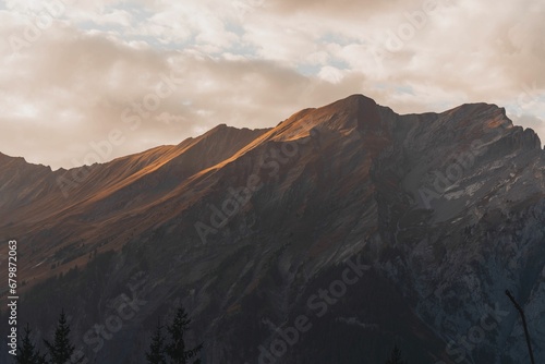 Top of a hill with a majestic mountainous landscape in the background: Swiss Alps