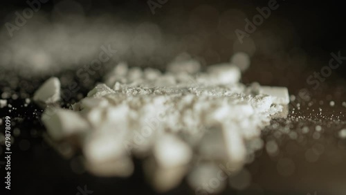 Focus shift at white crystalline powder made of crushed oxycodone prescription medications pills. Powdered drugs. Extreme macro close up of hand made Illegal narcotic substance.