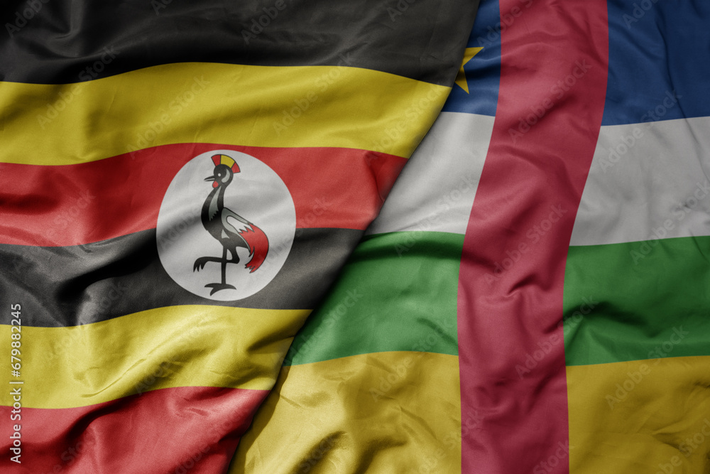 Fototapeta premium big waving national colorful flag of uganda and national flag of central african republic .