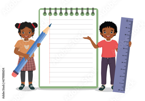 Cute little African kids holding big pencil and ruler standing with big notebook