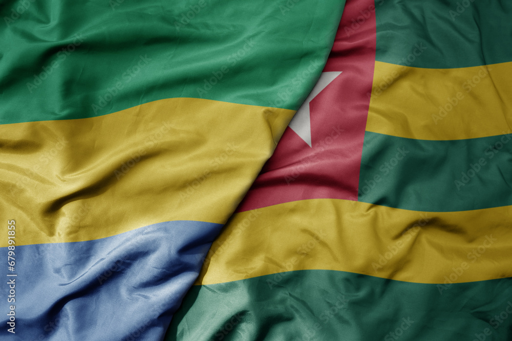 big waving national colorful flag of togo and national flag of gabon .