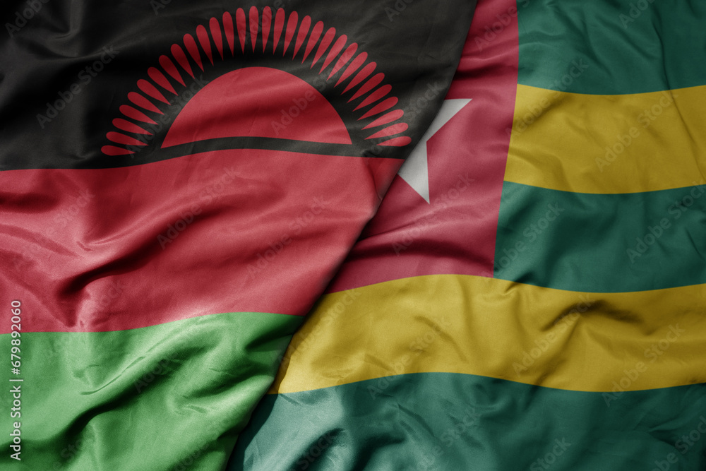big waving national colorful flag of togo and national flag of malawi .