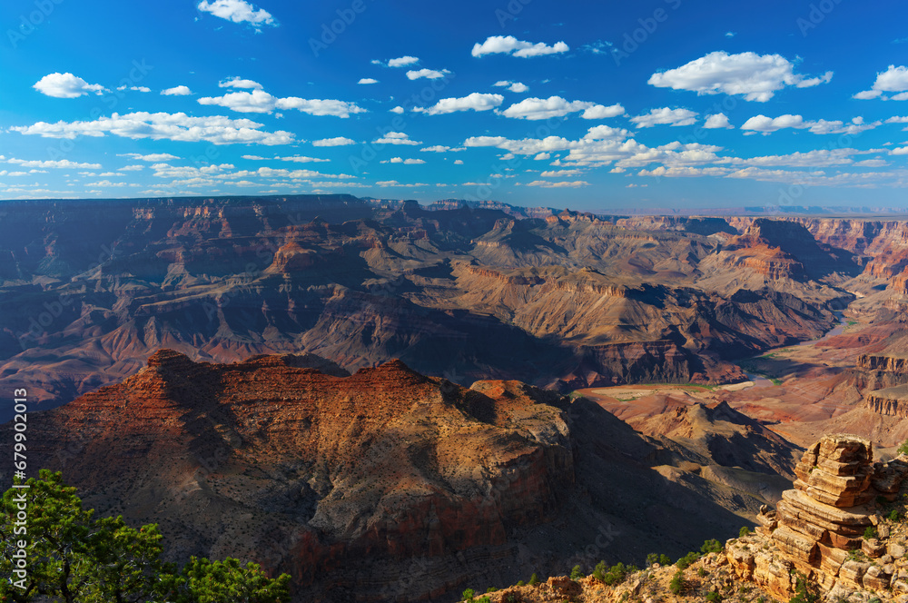Grand Canyon South Rim, vibrant colors, majestic, eroded geological feature. The Colorado River is shown on the right.