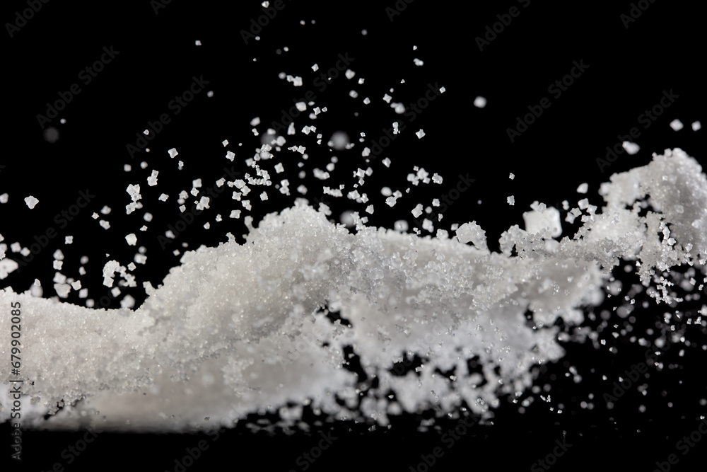 Salt powder pour fall in bowl, white Salt crystal cook abstract cloud fly. Ground salt splash in air, food object element design. Black background isolated selective focus blur