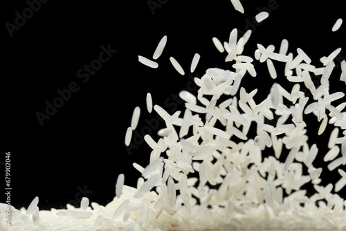 Fototapeta Naklejka Na Ścianę i Meble -  Japanese Rice flying explosion, white grain rices fall abstract fly. Beautiful complete seed jasmine rice splash in air, food object design. Black background isolated selective focus blur