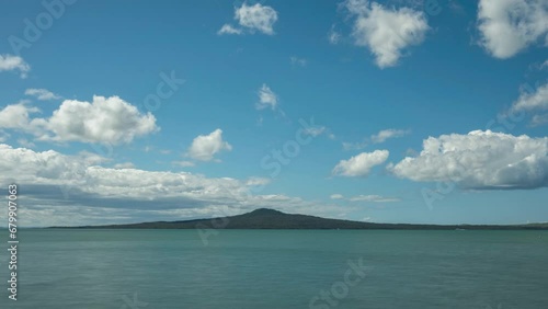 Timelapse of fluffy, white clouds forming and dissipating over volcanic Rangitoto Island in Auckland's Hauraki Gulf, New Zealand.