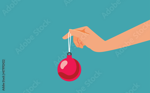 Hand Holding a Christmas Ball Vector Banner Design. Unrecognizable person offering a Christmas ornament as a gift 
